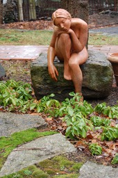 Terracotta figure sitting on stone
